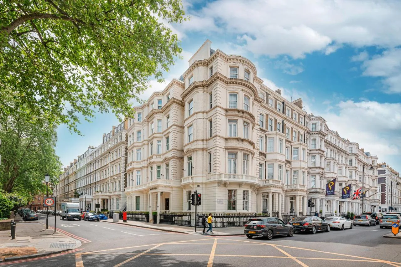 a large white building with cars parked in front of it at Ashburn Hotel in London
