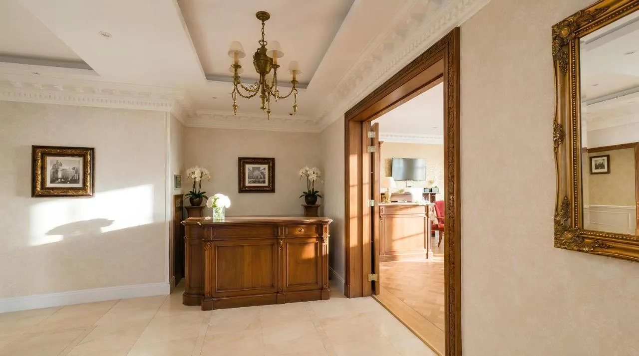 a hallway with a mirror and a room with a table at Ashburn Hotel in London